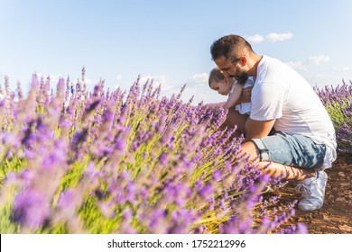 Spanish Father With His Daughter Having Fun In A Field Of Flowers. Spanish Family Into A Field Of Lavanda Flowers. Latin American Father Having Fun With Baby Outdoors. Family Concept.