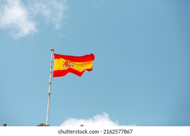 Spanish Flag Waving In The Clear Blue Sky. 