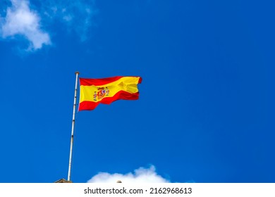 Spanish Flag Waving In The Clear Blue Sky. 