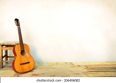 Spanish guitar propped in front of a white wall as background 