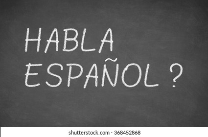 Spanish Language Learning Concept Image. Teacher Or Student Wrote HABLA ESPANOL On Blackboard During Spanish Language Course Class.