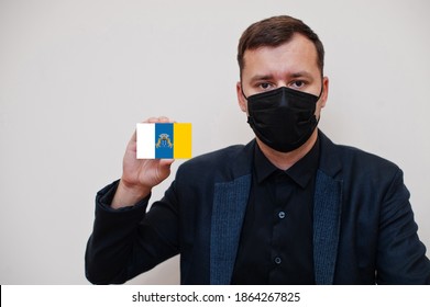 Spanish Man Wear Black Formal And Protect Face Mask, Hold Canary Islands Flag Card Isolated On White Background. Spain Autonomous Communities Coronavirus Covid Concept.