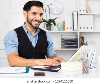 Spanish Man Is Working With Documents In Laptop In Office.