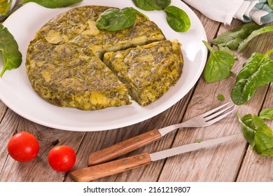 Spanish omelette with spinach on white dish.