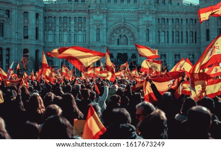 Spanish protesting while waving the flag of spain