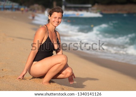 Spanish sea resort. Girl in swimsuit on sandy beach in Lloret de Mar, Costa Brava, Spain