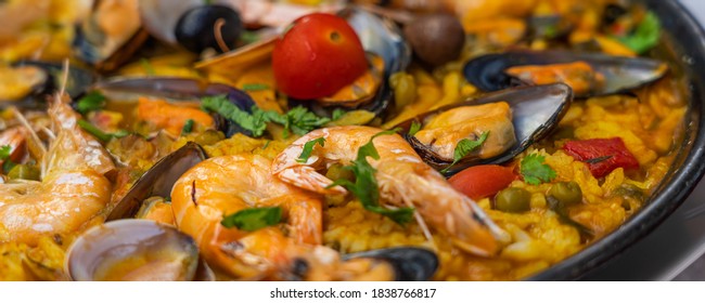 Spanish seafood Paella de Marisco, Paella Marinera with mussels, shellfish and scampis, panorama view
