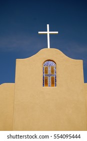 Spanish Style Catholic Church Stained Glass Cross Window Arch With The Cross On The Roof With A Beautiful Blue Sky Background