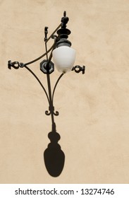 Spanish Style Exterior Wrought Iron Wall Light Casting a Shadow
