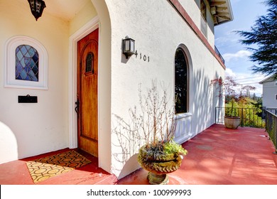 Spanish Style White House With Red Concrete Porch And Front Door.