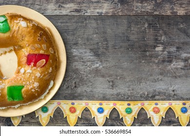 Spanish typical epiphany cake "Roscon de Reyes", on wooden background
