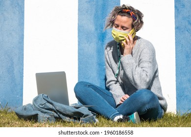 A Spanish woman having a conversation over her phone against a blue and white wall