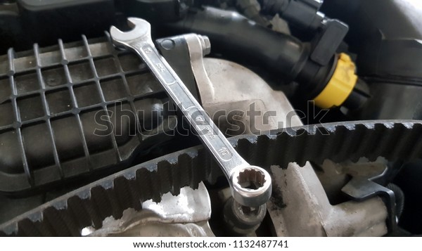 Spanner and timing belt on car engine ready for\
service repair