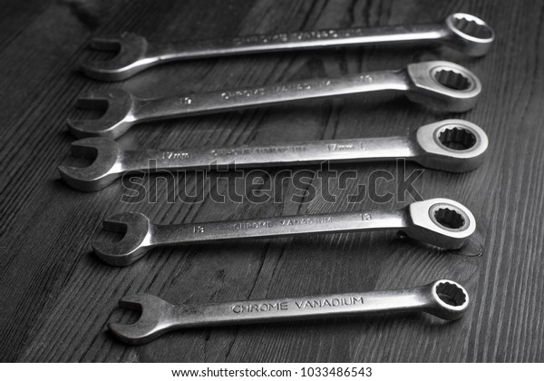 spanners on a black wooden\
texture
