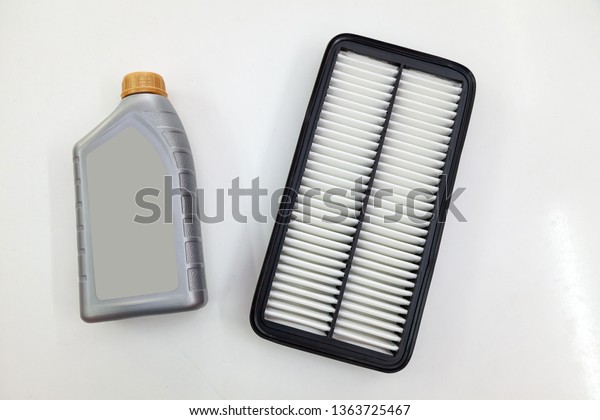 Spare part for car engine air filter for\
cleaning dust and dirt with one liter bottle or can of lubricant on\
a white isolated background. Maintenance and oil change in auto\
service industry.