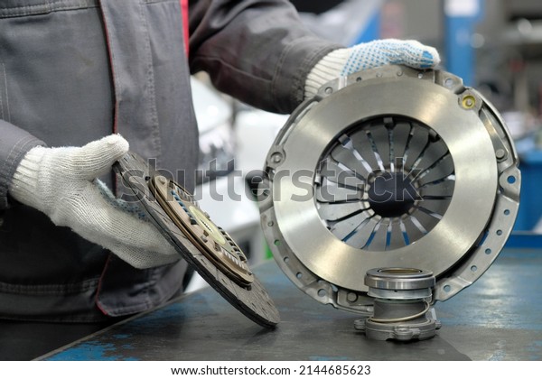 Spare parts for cars. Car clutch kit. An\
auto mechanic monitors the compliance and integrity of the drive\
disc, the driven disc and the exhaust\
bearing.