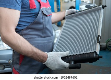 Spare Parts. Radiator Of The Engine Cooling System Close-up. A Car Mechanic Checks The New Radiator Before Replacing The Faulty One. Repair And Maintenance.