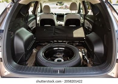 Spare Wheel In The Trunk Of A Modern Car. Jack Lifting And A Spare Tire In Rear Of Car.