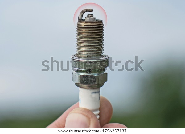 Spark plugs in hand. Worn spark plugs to be\
replaced. Car consumable\
component.