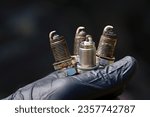 Spark plugs replacement. Change old spark plugs, mechanic holding three old copper spark plugs and new one. Maintenance of ignition system of gasoline engine.
