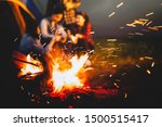 Sparking bonfire with tourist people sit around bright bonfire near camping tent in forest in summer night background. Group of student at outdoor fire fuel. Travel  activity and long vacation weekend