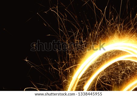 Sparkler background / A sparkler is a type of hand-held firework that burns slowly while emitting colored flames, sparks, and other effects