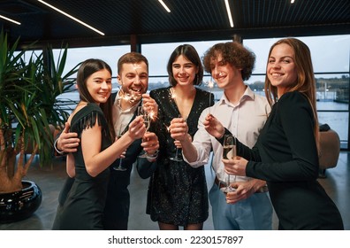 Sparklers light. Group of people in beautiful elegant clothes are celebrating New Year indoors together. - Shutterstock ID 2230157897