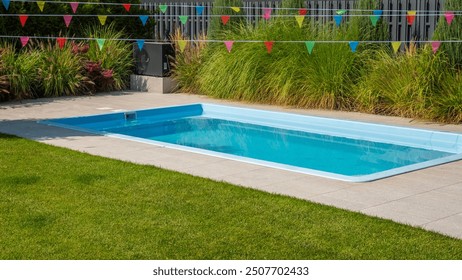 Sparkling backyard pool surrounded by greenery and festive flags.