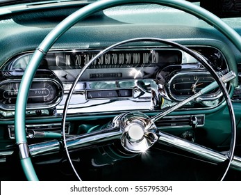 A sparkling closeup of a chrome and teal antique car dashboard with sun reflections at a car show in Mizner Park, Boca Raton FL - Powered by Shutterstock