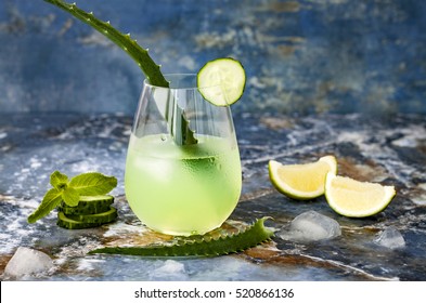 Sparkling cucumber mint gin and tonic fizz with aloe vera on marble table. Copy space. Dragon tail cocktail for fans party