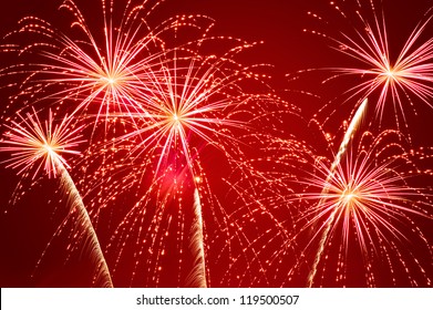 Sparkling Flashes Of A Festive Firework On Deep Red Background