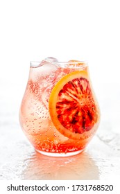 A Sparkling Iced Cocktail With Blood Orange On White Background