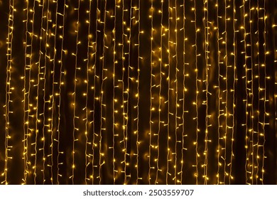 Sparkling led yellow lights running vertically. A curtain of Christmas fairy lights. Fairy light strips - Powered by Shutterstock