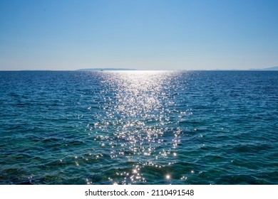 Sparkling sea in the sunlight with Croatian islands in the background, blue sky