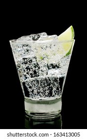 Sparkling Water With Ice Cubes And Piece Of Lime In Old Fashion Glass On A Black Background