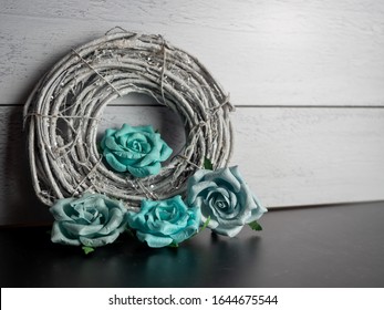 Sparkly Gray Nest Wrapped Up With Teal Blue Paper Rose Flower Blooms On A Black Slate And Shiplap Background.