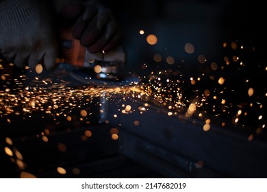 Sparks in dark. Metal grinding. Orange lights fly in different directions. Work in metal workshop. Steel processing with grinder. Background of many sparks. - Powered by Shutterstock