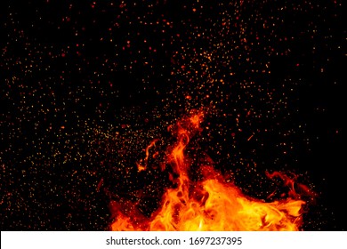 sparks of fire on a black background.  flame of fire with sparks. Burning red hot sparks fly from large fire in the night sky. Beautiful abstract background on the theme of fire, light and life. 