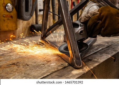 Sparks fly from blacksmith disc grinder. A close up view of an abrasive disc cutter in use. Hands of a skilled worker operate power tool inside a workshop. Hot sparks fly from the abrasive wheel. - Powered by Shutterstock