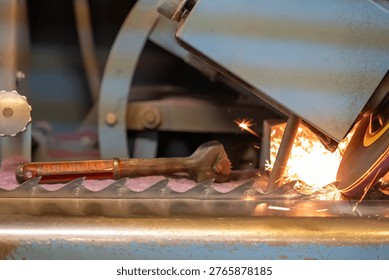 Sparks fly from a grinding machine while shaping metal on a workshop bench