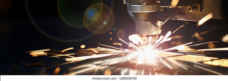 Sparks fly out machine head for metal processing laser metal on metallurgical plant background. Manufacturing finished parts for automotive production concept - Shutterstock ID 1380508700