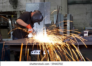 sparks frying over the working table during metal grinding - Powered by Shutterstock