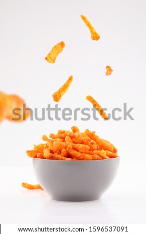 sparse stick corn chips in gray bowl isolated on white background