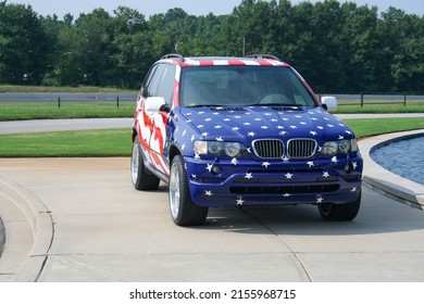 SPARTANBURG, UNITED STATES - Aug 03, 2006: A 2006 BMW X5 Car Painted In The American Flag Parked On A Curb Outside The Manufacturing Plant