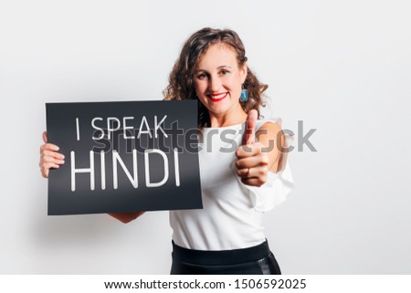 I speak Hindi phrase inscription on a board. Smiling woman showing approved sign with her hand.
