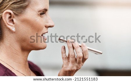 Speak success into your life. Shot of a mature businesswoman using a smartphone against an urban background.