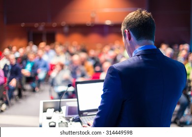 Speaker At Business Conference With Public Presentations. Audience At The Conference Hall. Entrepreneurship Club. Rear View. Horizontal Composition. Background Blur.