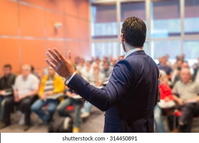 Speaker At Business Conference With Public Presentations. Audience At The Conference Hall. Entrepreneurship Club. Rear View. Horizontal Composition. Background Blur.