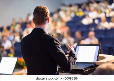 Speaker At Business Conference With Public Presentations. Audience At The Conference Hall. Entrepreneurship Club. Rear View. Horisontal Composition. Background Blur.