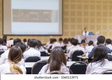 Speaker Giving Educational Seminar, School Lecture, Or Entrepreneurship Business Talk  Blur Background In Conference Meeting  With Audiences Or Students In Back Of The Room 